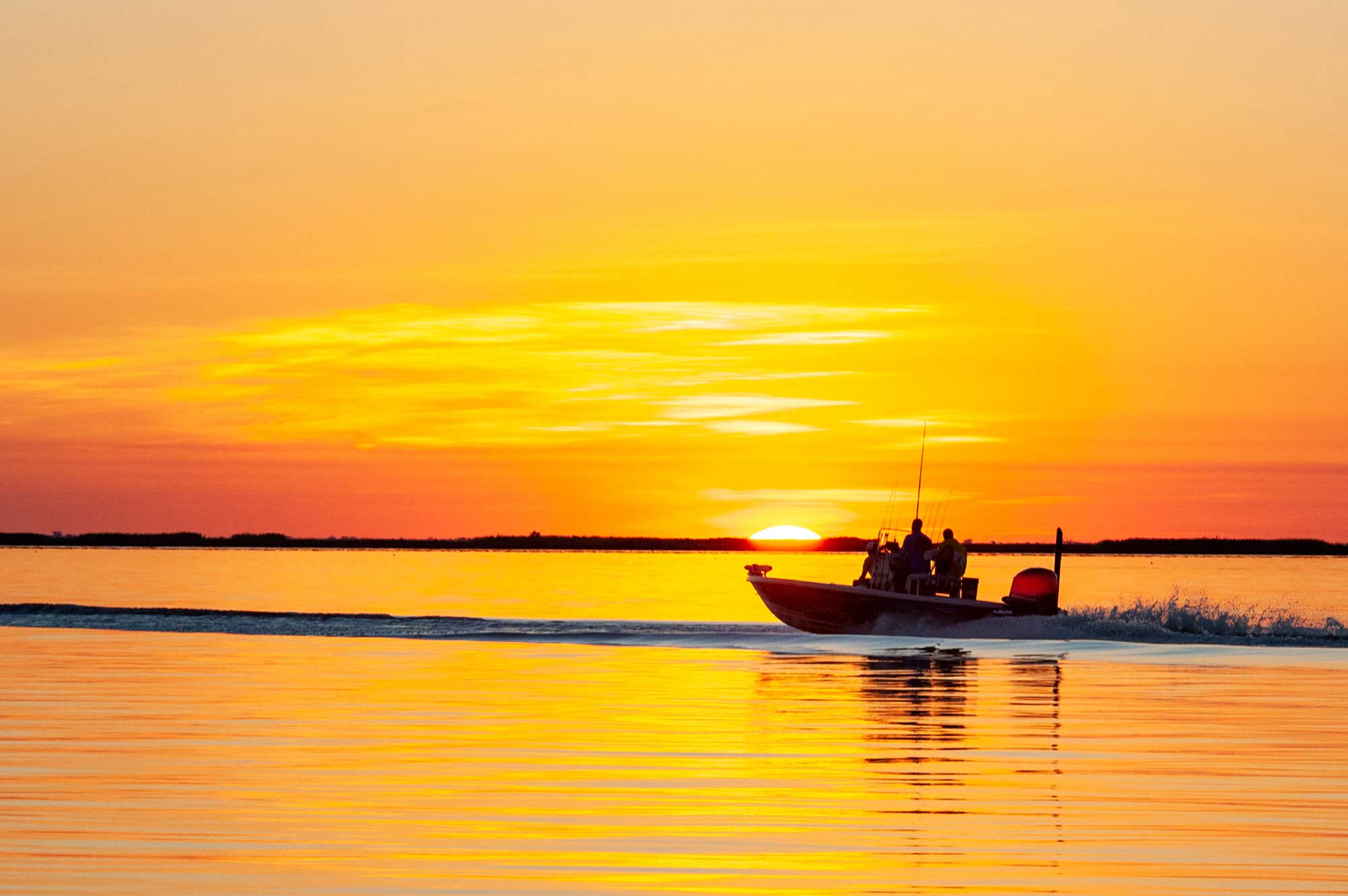 people on boat sailing river sunset